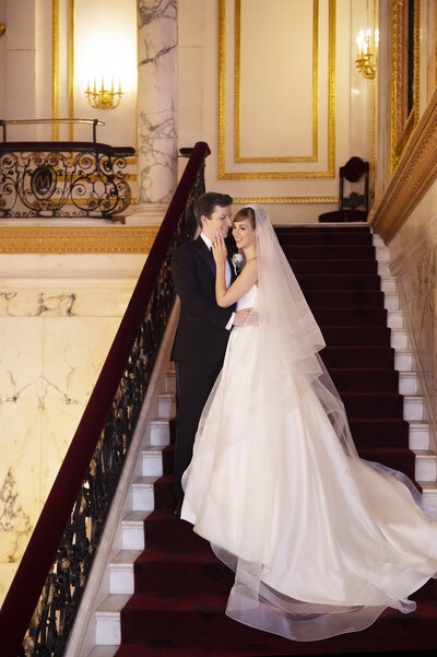 Bride and groom embracing on staircase