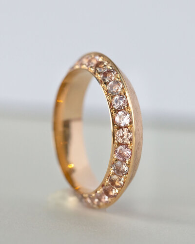 A gold and gemstone ring with a triangular profile