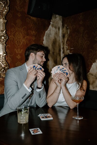 engaged couple playing card game at bar
