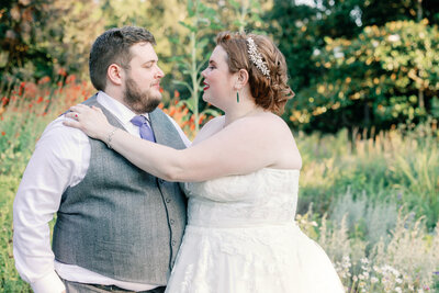 bay area photographers captures outdoor engagement pictures with man and woman at a vineyard with the man wrapping his arms around the woman's shoulders