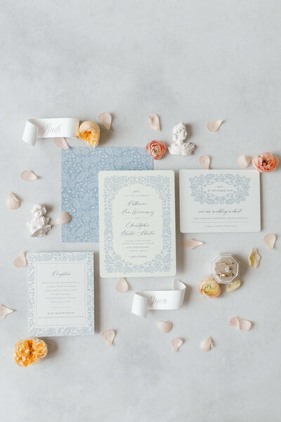 Wedding invitation suite with soft pastel florals, rings, and decorative elements, captured by a Virginia wedding photographer.