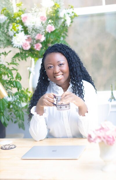 Public Speaking Coach Brenda Chadambura  Sitting At a Table with a Coffee Mug - Brenda Chadambura
