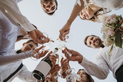 Mariés et invités trinquant ensemble au champagne. Vue de dessous. Organisation d'événements en vendée et Loire Atlantique.