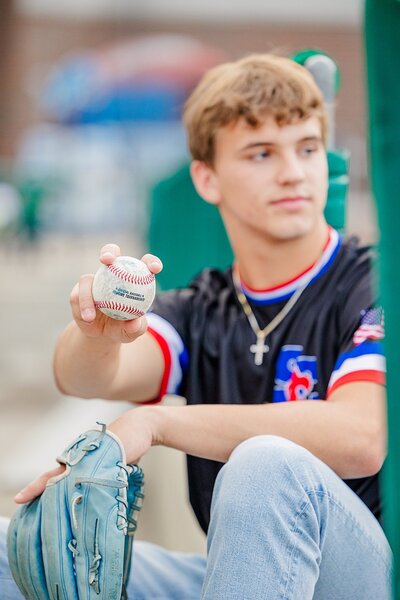 High school senior holding baseball and glove at Corner Ballpark in Detroit