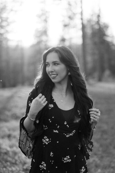 Black and white photo of Aurelia from Aurelia K Photography, smiling and looking away from the camera.