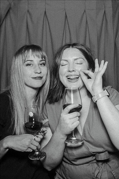 two young girls in photo booth with wine glasses