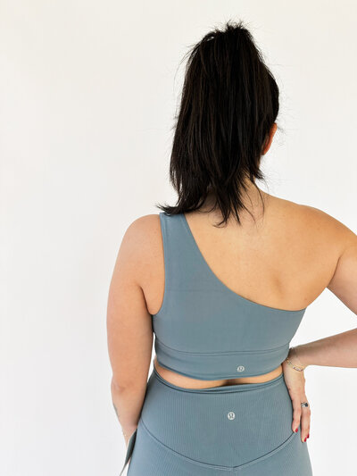 back of woman wearing belgin blue asymmetrical lululemon bra