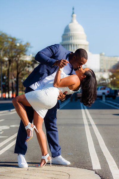 A couple dips while kissing in the street in front of the US Capitol building