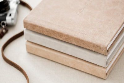 leather bound albums stacked together in neutral colors