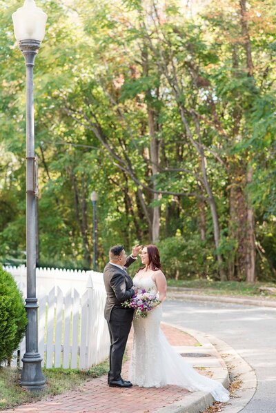 groom caressing bride by a lamp post