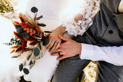 The bride's side profile standing in front of the church with her dress train fluffed out trailing behind her and looking behind over her shoulder