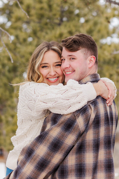 ​​Couple joyfully embracing during their engagement session at Hynds Lodge near Curt Gowdy Wyoming, capturing their love in a stunning natural setting.