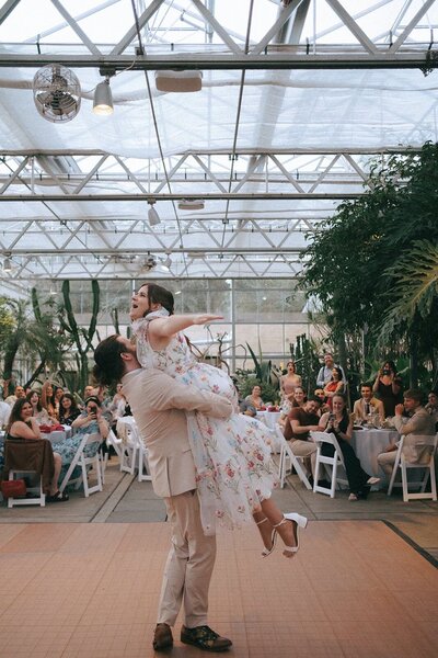 Groom lifting his bride into the air during their first dance. Dance floor at Roger Williams Botanical Center wedding in Providence. Photo by Rhode Tripper Photography