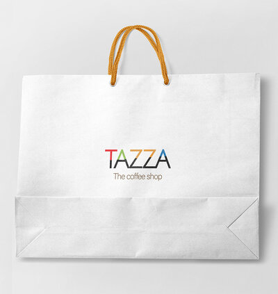 White shopping bag with "TAZZA The coffee shop" logo and brown rope handles.