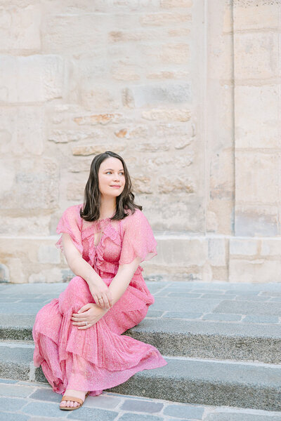 Woman wearing pink dress during solo Paris photoshoot at Ile Saint Louis 