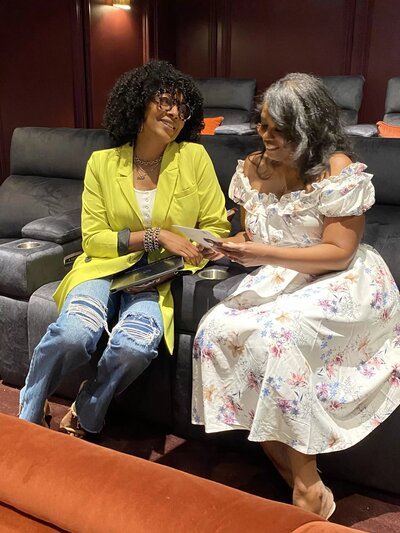 two women sitting together laughing