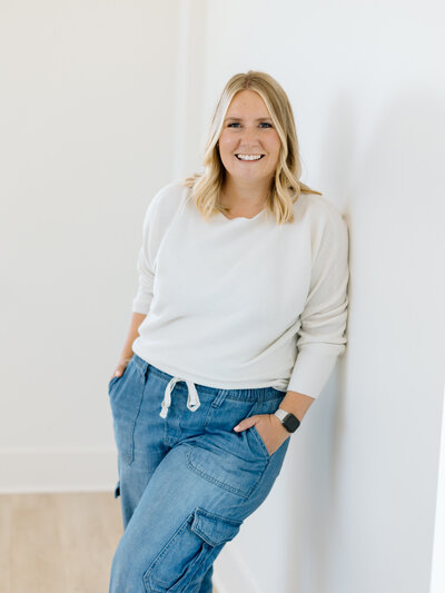 woman poses against white wall