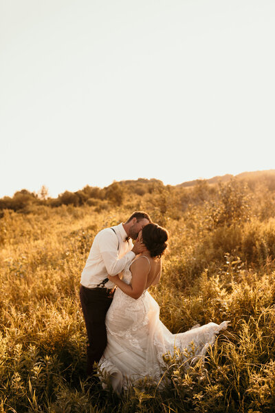 couple kissing in a grass field