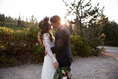 groom holding bride, about to kiss her at sunset
