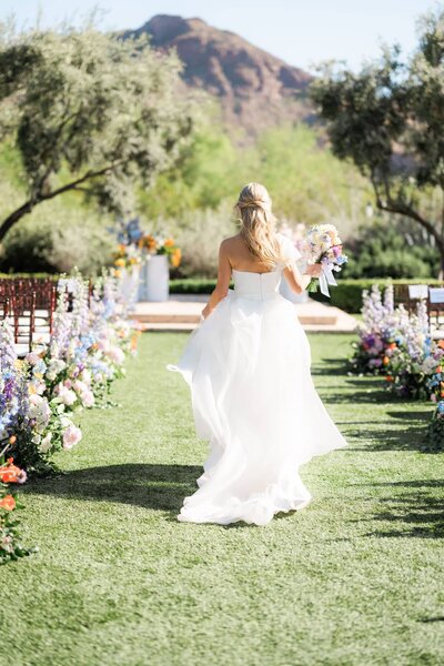 Bride running down the aisle of her wedding at El Chorro Scottsdale.