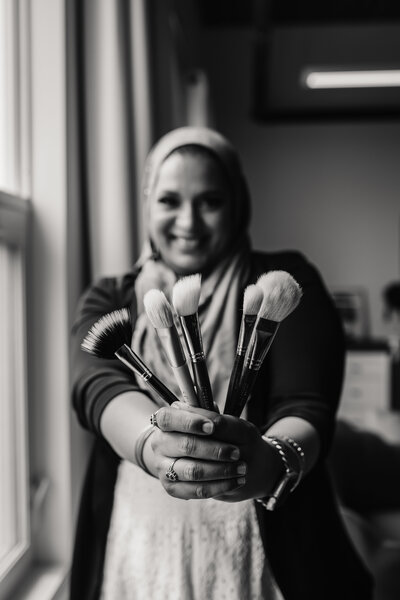 Maya holding makeup brushes and soft glam essentials
