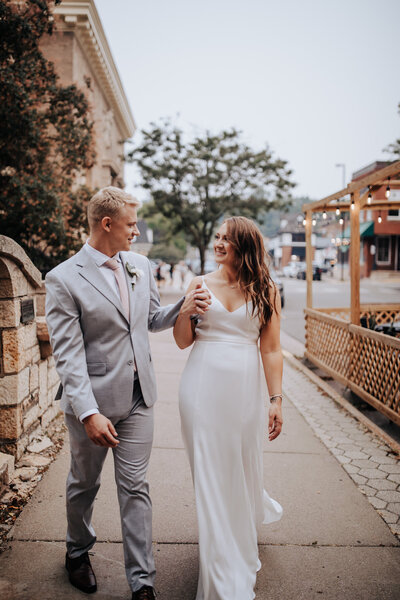 Destination wedding photographer captures couple holding hands and walking at their Minnesota wedding