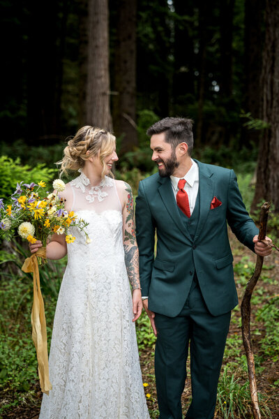 Bride Amanda and groom Aaron share a genuine laugh during a playful wedding photo session in the enchanting redwood grove at Ridgefield in Arcata, California.