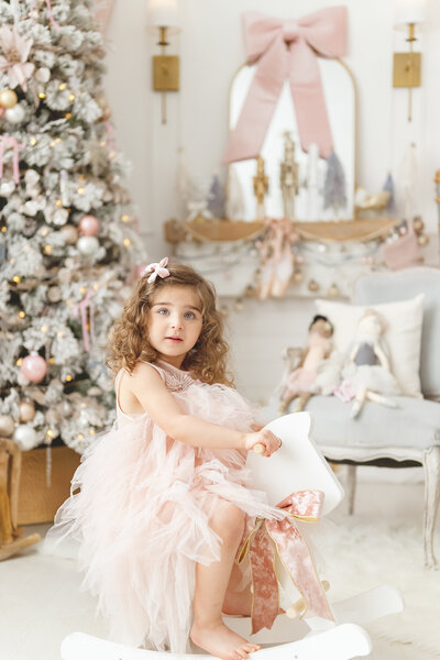 Girl in pink dress sitting on white rocking horse in Phoenix nutcracker ballet mini session photos