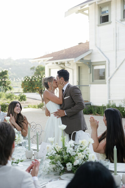 Bride and Groom celebrating and kissing at their outdoor wedding reception captured by a Wisconsin Wedding Photographer.