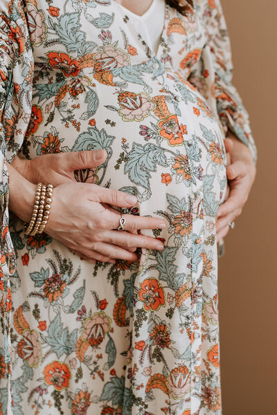 Embrace the tender moments of a studio maternity session as a father lovingly cradles the pregnant belly of his partner. This heartwarming image captures the anticipation and connection between a dad and mom-to-be. Witness the beautiful bond of parenthood as the father's hands gently rest on the expectant mother's bump in a serene studio setting. Professional maternity photography celebrating the shared joy and intimacy of a couple awaiting their new arrival, depicted in this touching and emotionally resonant moment