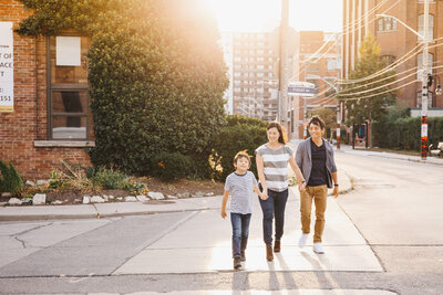 Family of 3 walking across street