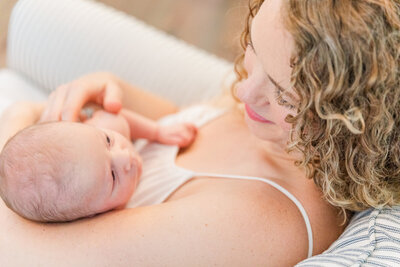 lifestyle portrait of mommy looking her her newborn baby by Laure Glorieux Photography