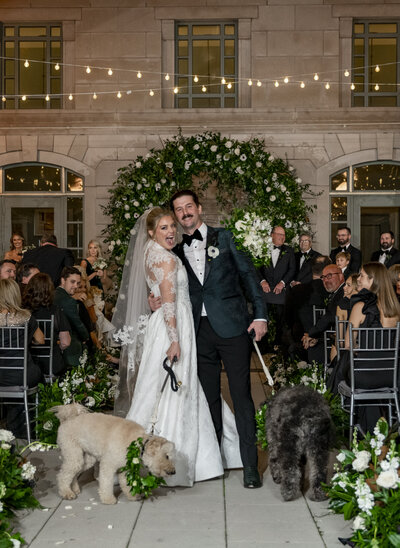 Sabina in her Galia Lahave wedding dress holding a goat with a flower collar.