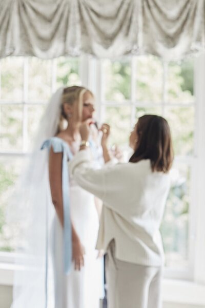 Woman applying makeup to a client