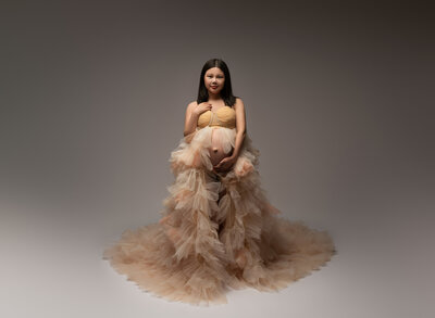 Peach layered ruffle maternity gown with gold bandeau top and full train