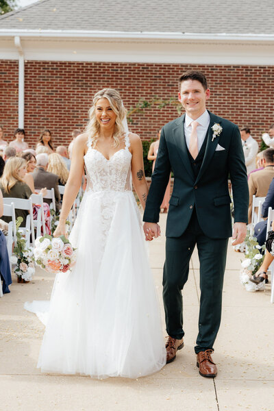 Bride and Groom walking down the aisle at Aurora Meadows.