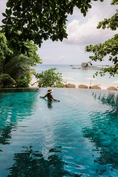 Woman standing on the infinity swimming pool with an ocean view