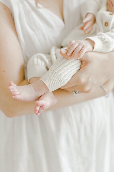 mom holding newborn baby showing her little toes