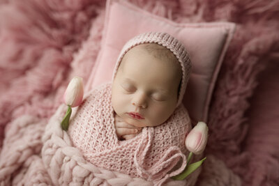 Baby girl in pink. Pink spring tulips