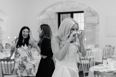 an emotional bride wiping tears from her eyes during a wedding reception at grbic events in st. louis
