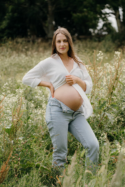 A woman with her hands on her hips during her maternity photoshoot with auckland and waikato photographer tashina narelle photography