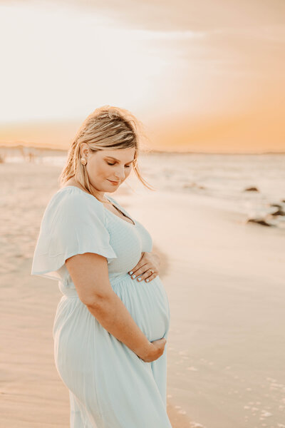 a pregnant women posing at Sandy Hook beach in New Jersey for a beach maternity session