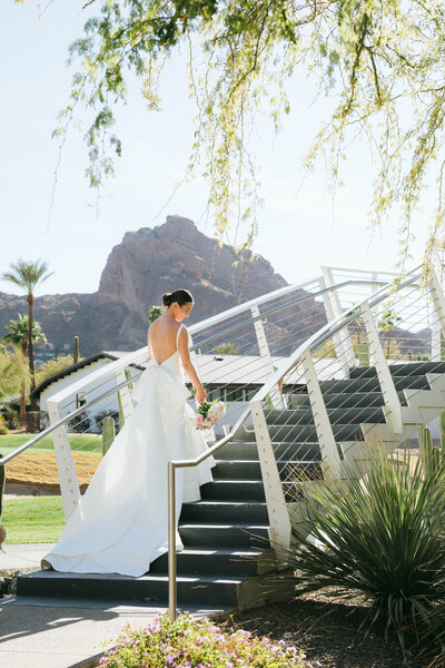Bride walking up the stairs at Mountain Shadows Scottsdale, captured by Phoenix wedding photographers Joy and Ben Photography, specializing in elegant Arizona wedding photography.