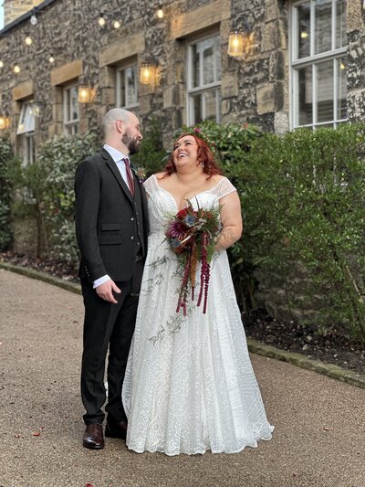 Autumn bride and groom laughing with each other 