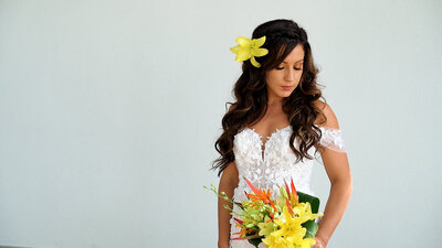 Bride holding a yellow tropical wedding bouquet.
