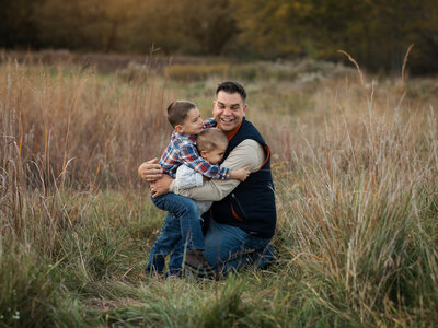 two sons hugging dad at park for family photos Cleveland family photography