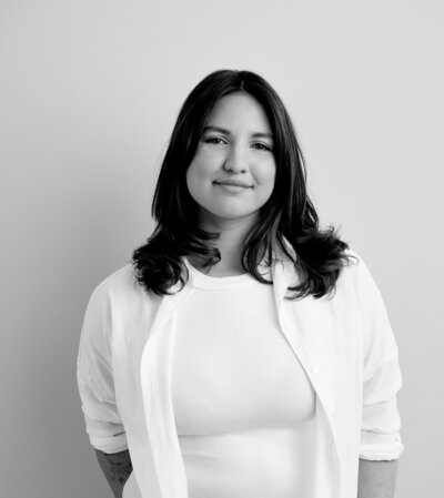 Black and white photo of woman with shoulder-length dark hair softly smiles.