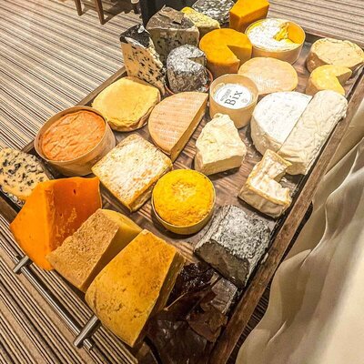 A giant cheeseboard with numerous different cheeses