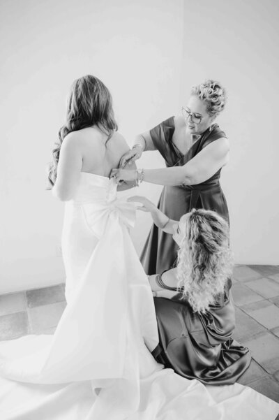 Mother of the bride and a bridesmaid helps bride getting ready at La Bonne Vie Ranch