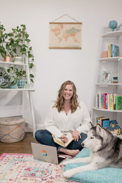Pinterest strategist Julia Bocchese sitting on office floor with husky